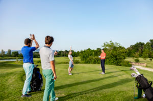 Friends playing golf on golf course Friends playing golf on golf course